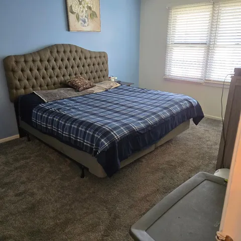 a bedroom with a bed and window