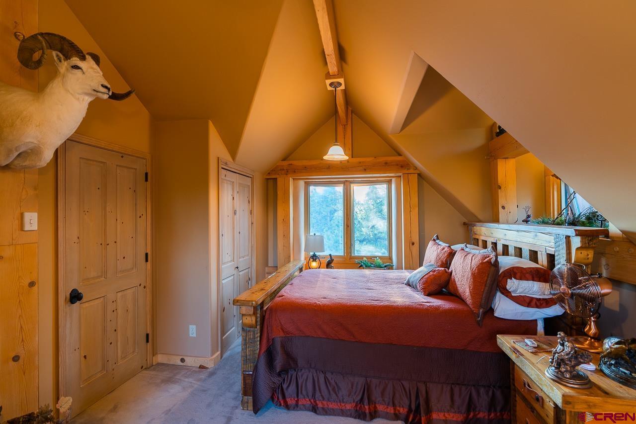 200 Longview Lane Bayfield, CO 81122 - Photo 21 of 33 a bedroom with a bed a dresser and potted plants