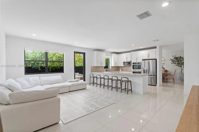 a kitchen with stainless steel appliances a table and chairs in it