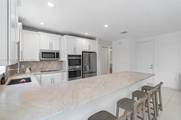 a living room with kitchen island furniture and a flat screen tv