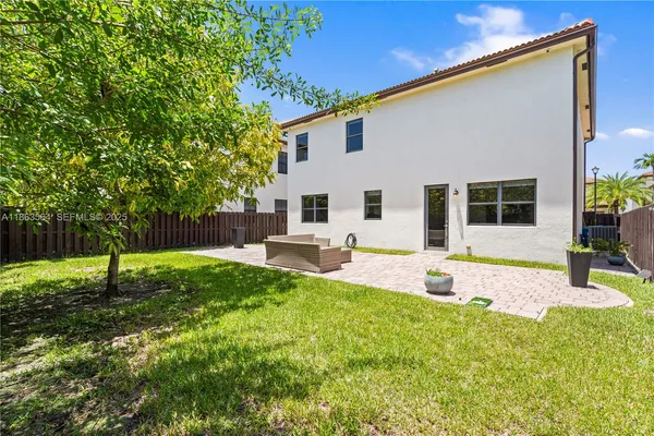a white bench sitting in the backyard of a house