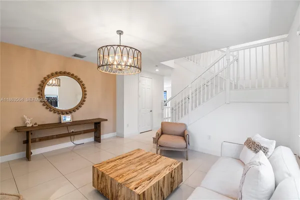 a living room with furniture a mirror and a wooden floor
