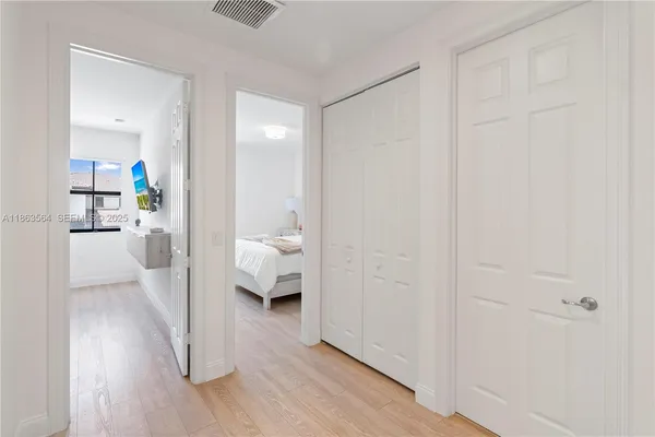 a bedroom with a bed a dresser and next to a window