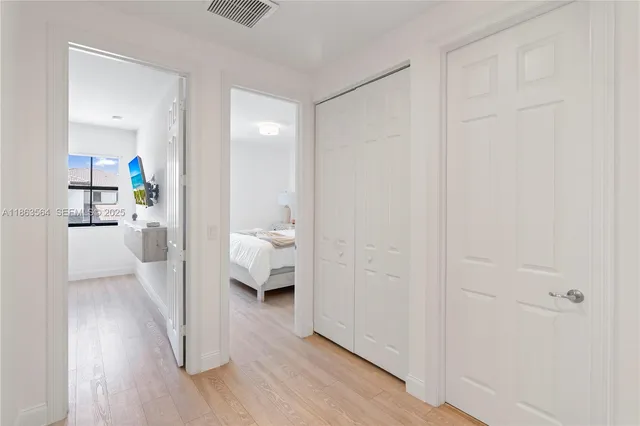 a bedroom with a bed a dresser and next to a window