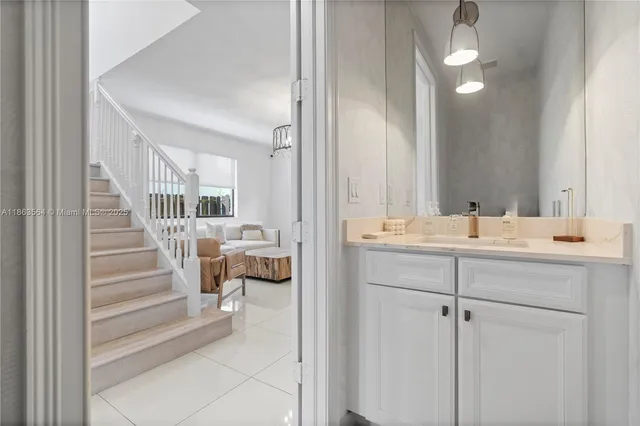 a large white kitchen with a refrigerator and a sink