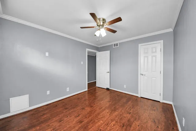 a view of a big room with wooden floor and a ceiling fan