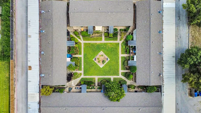 an aerial view of a residential houses with yard