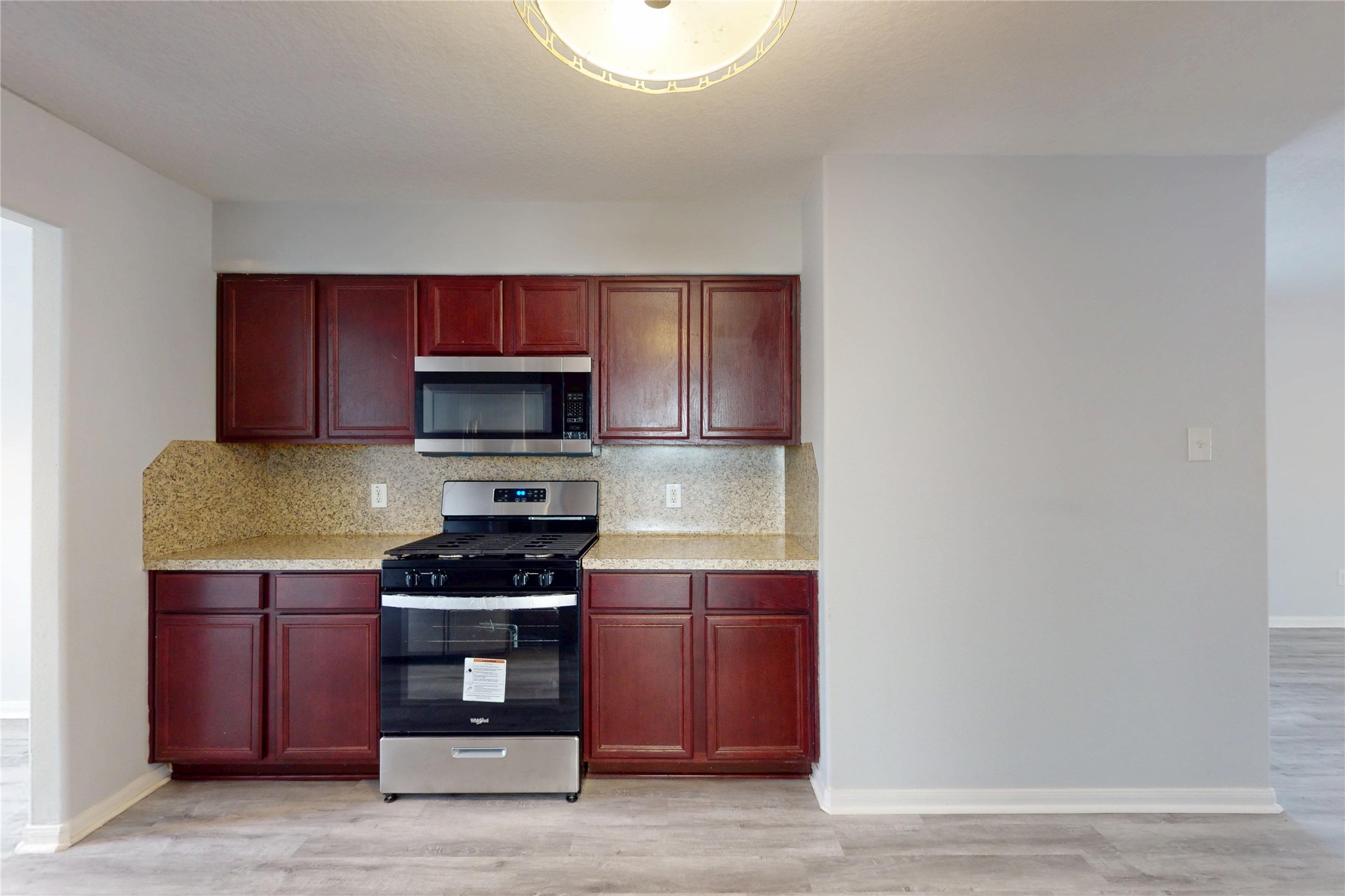 9877 Lace Flower Way Conroe, TX 77385 - Photo 11 of 43 a kitchen with granite countertop a stove and a microwave