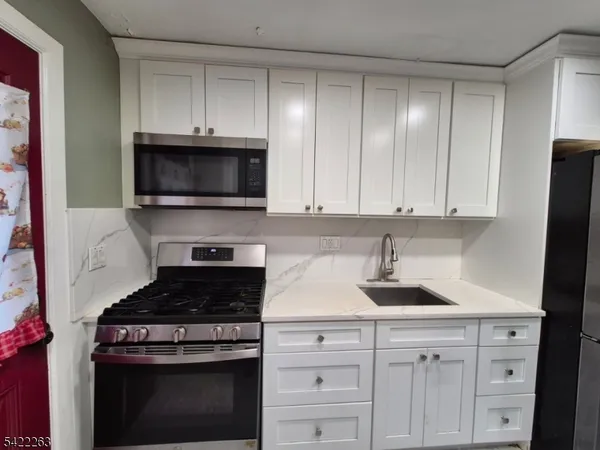 a kitchen with white cabinets and stainless steel appliances