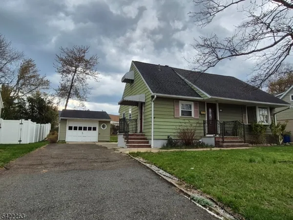 a front view of a house with a yard and trees