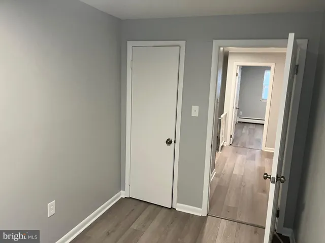 an empty room with wooden floor and mirror