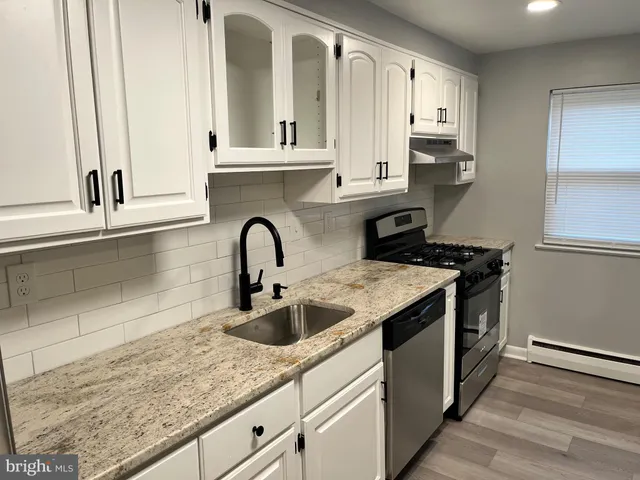 a kitchen with granite countertop a sink and cabinets