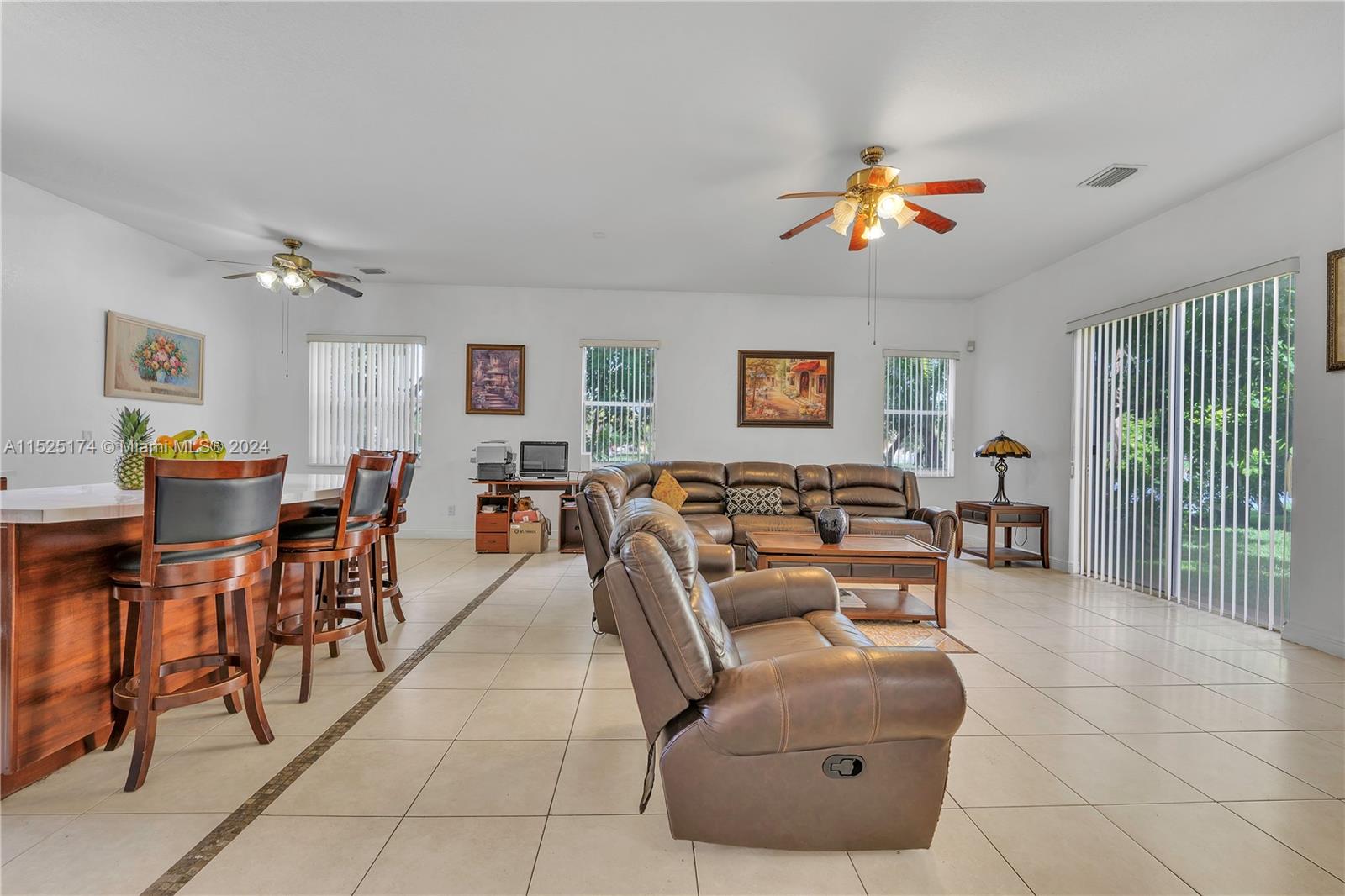 14093 Southwest 53rd Street Miramar, FL 33027 - Photo 18 of 45 a living room with furniture a dining table and a bookshelf
