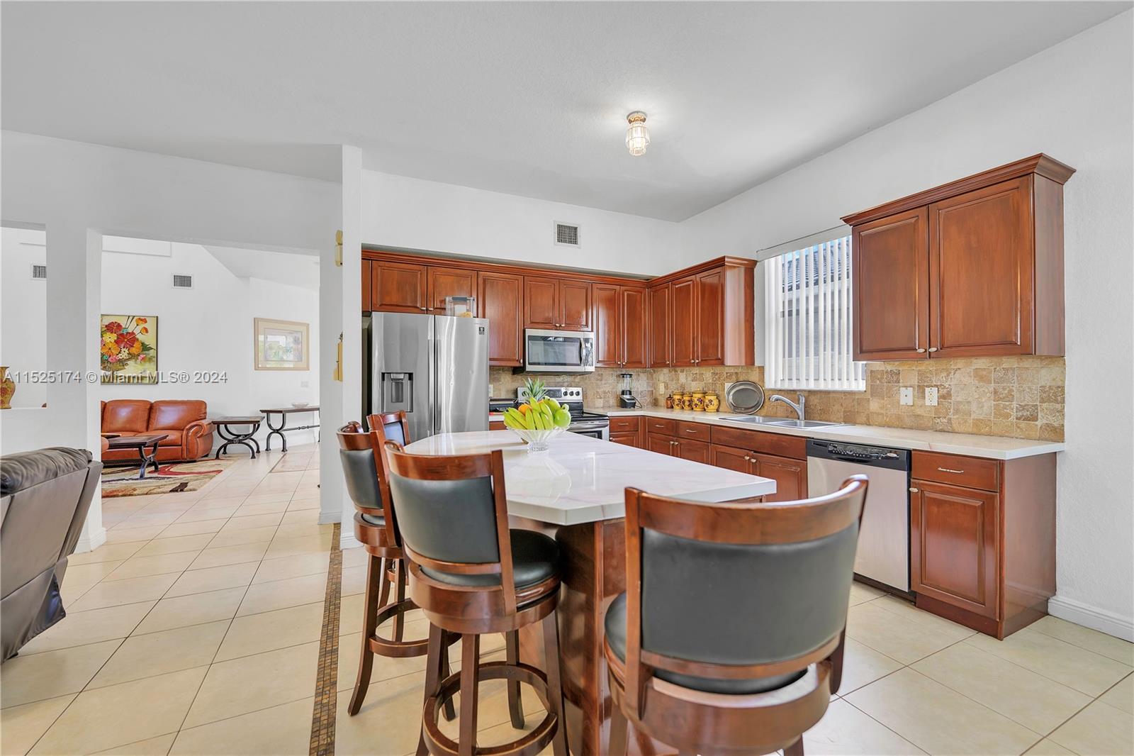14093 Southwest 53rd Street Miramar, FL 33027 - Photo 20 of 45 a kitchen with a table chairs and a sink