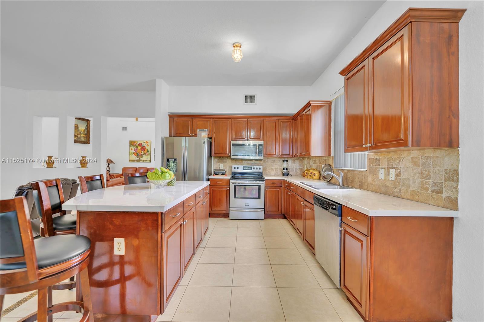 14093 Southwest 53rd Street Miramar, FL 33027 - Photo 21 of 45 a large kitchen with a large counter top space a sink stainless steel appliances and cabinets