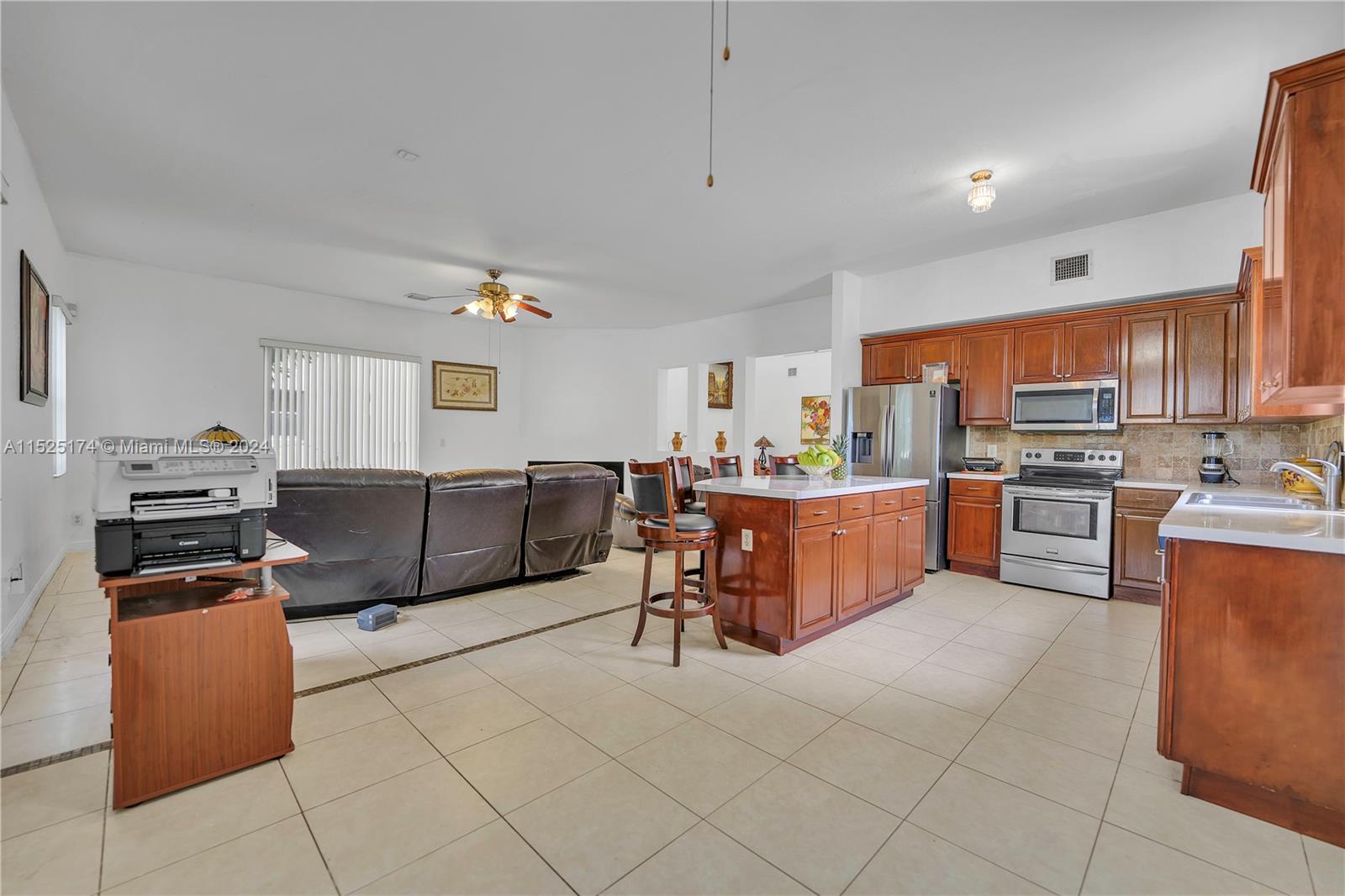 14093 Southwest 53rd Street Miramar, FL 33027 - Photo 22 of 45 a kitchen with stainless steel appliances a stove a sink a refrigerator a dining table and chairs