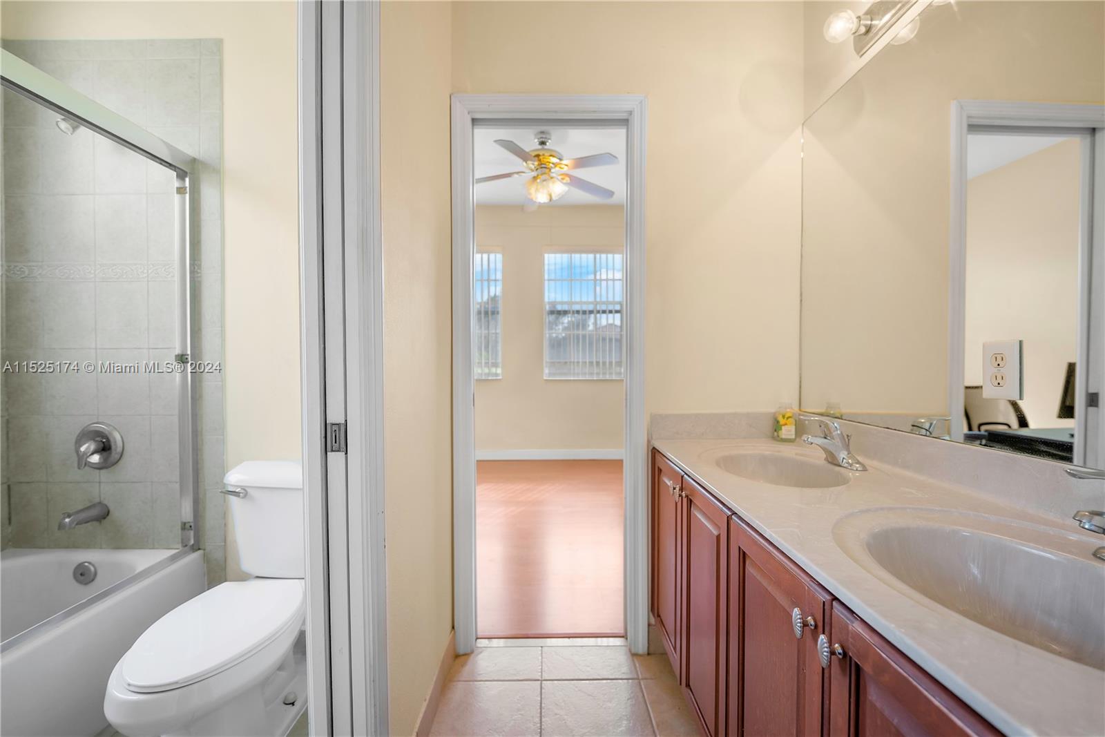 14093 Southwest 53rd Street Miramar, FL 33027 - Photo 39 of 45 a en suite bathroom with a granite countertop toilet sink and mirror