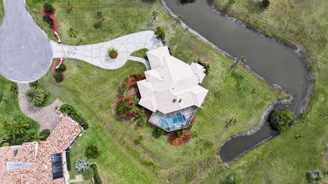 an aerial view of a house with a yard and lake