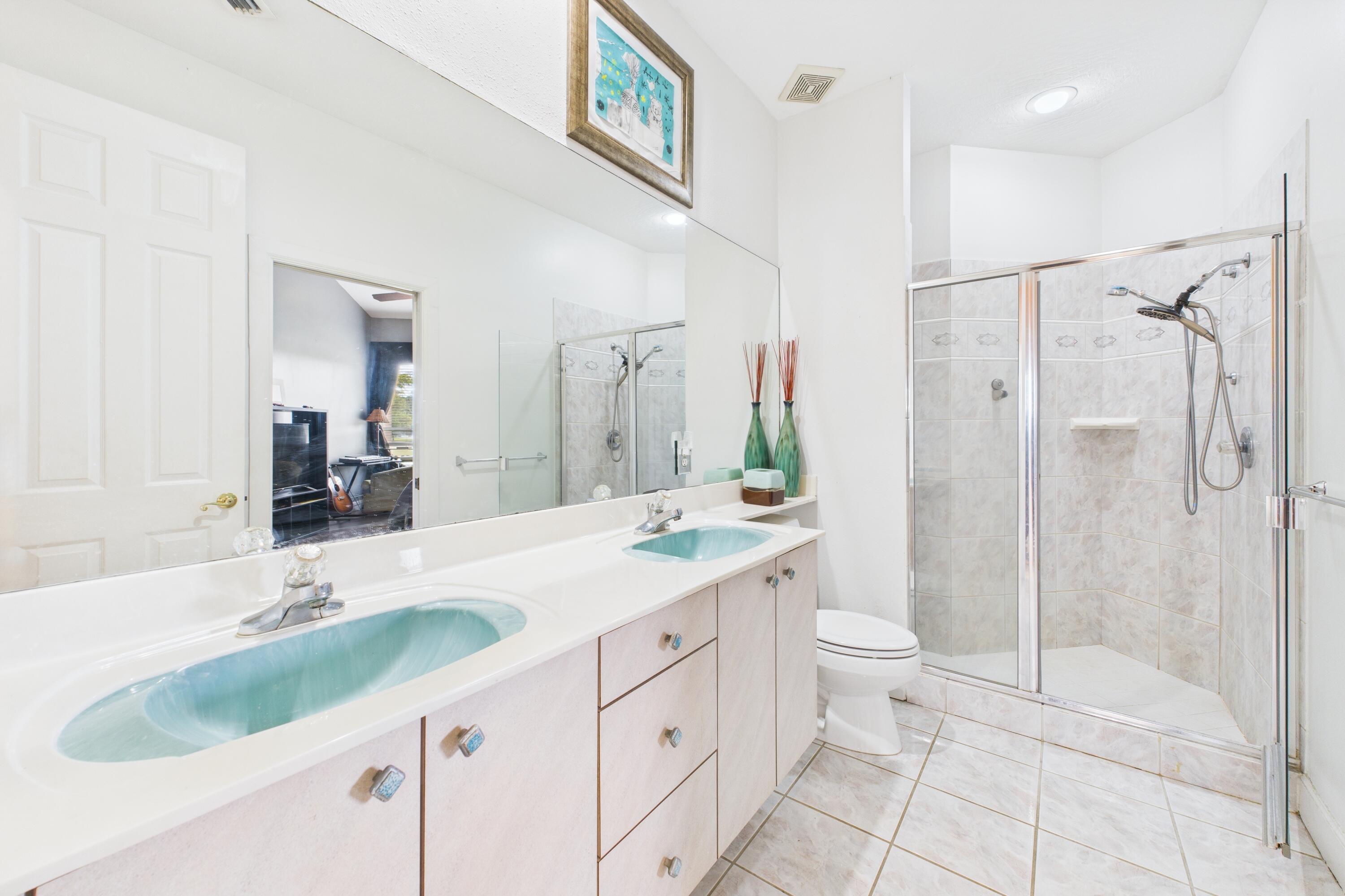 909 Preakness Place Rockledge, FL 32955 - Photo 19 of 24 a bathroom with a granite countertop sink a toilet a mirror and shower