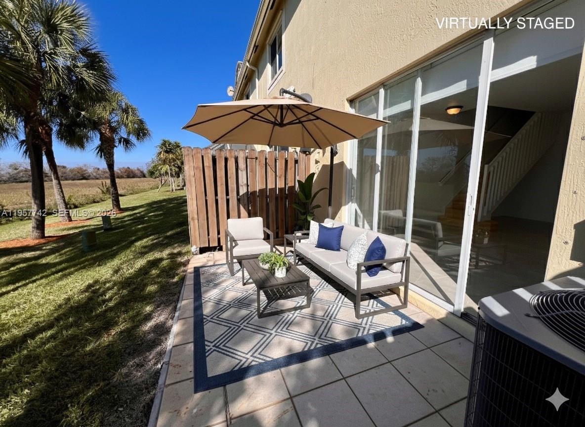2433 Pasadena Way Weston, FL 33327 - Photo 18 of 20 an outdoor sitting area with furniture and umbrella