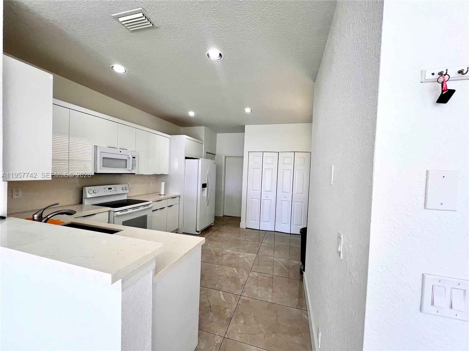 2433 Pasadena Way Weston, FL 33327 - Photo 3 of 20 a kitchen with stainless steel appliances a refrigerator and a stove