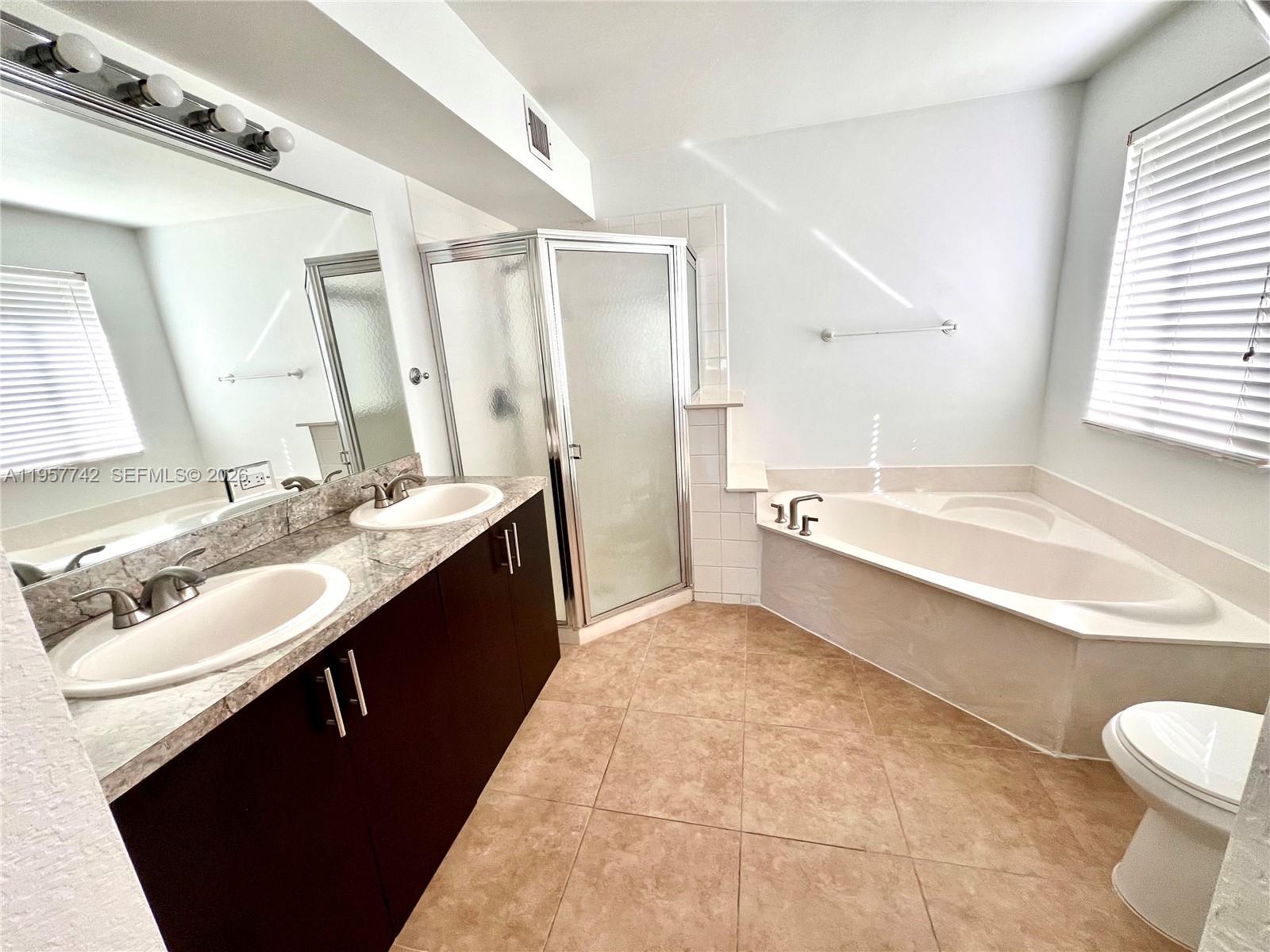 2433 Pasadena Way Weston, FL 33327 - Photo 6 of 20 a spacious bathroom with a bathtub sink and a mirror