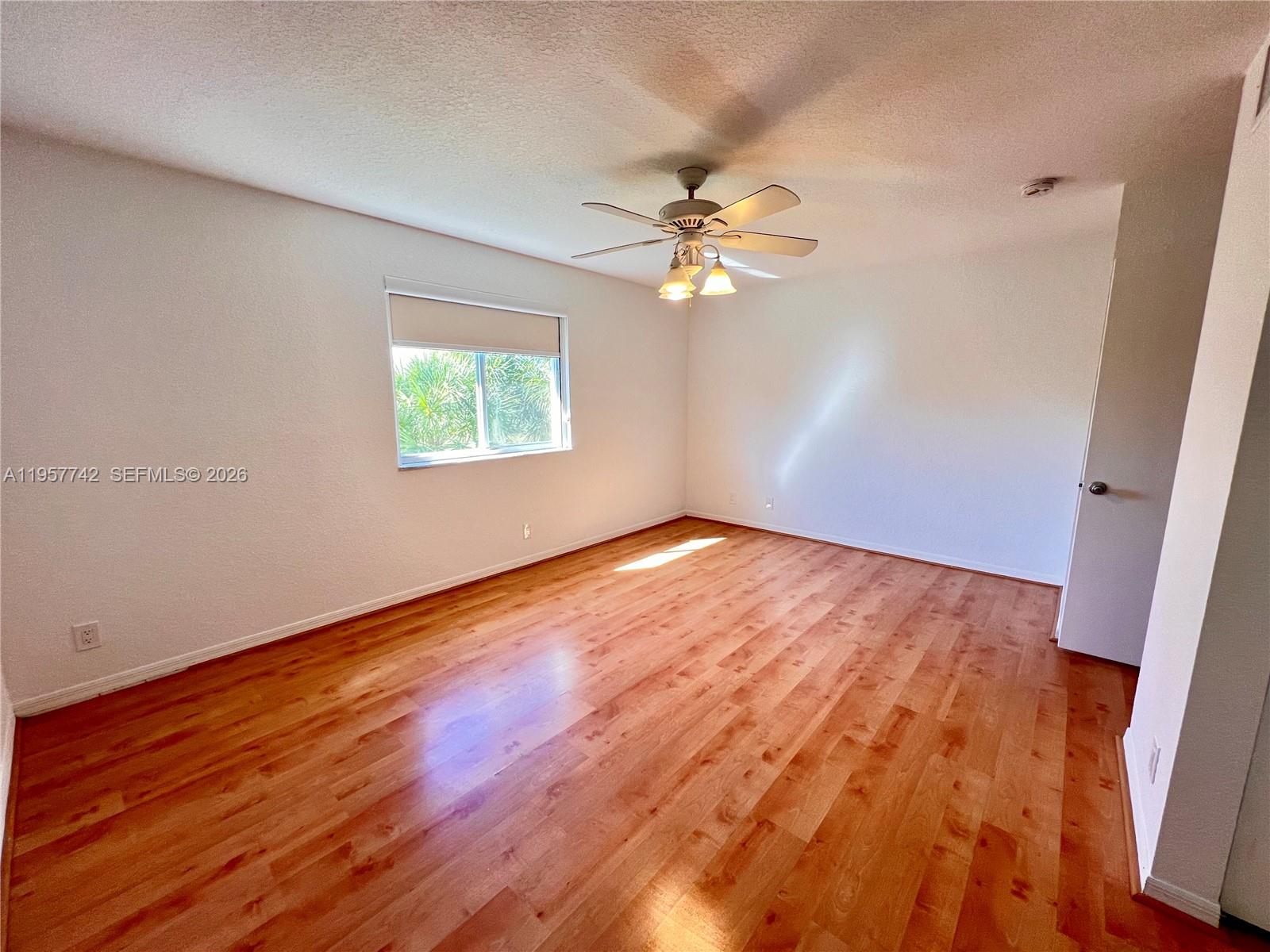 2433 Pasadena Way Weston, FL 33327 - Photo 7 of 20 an empty room with wooden floor fan and window