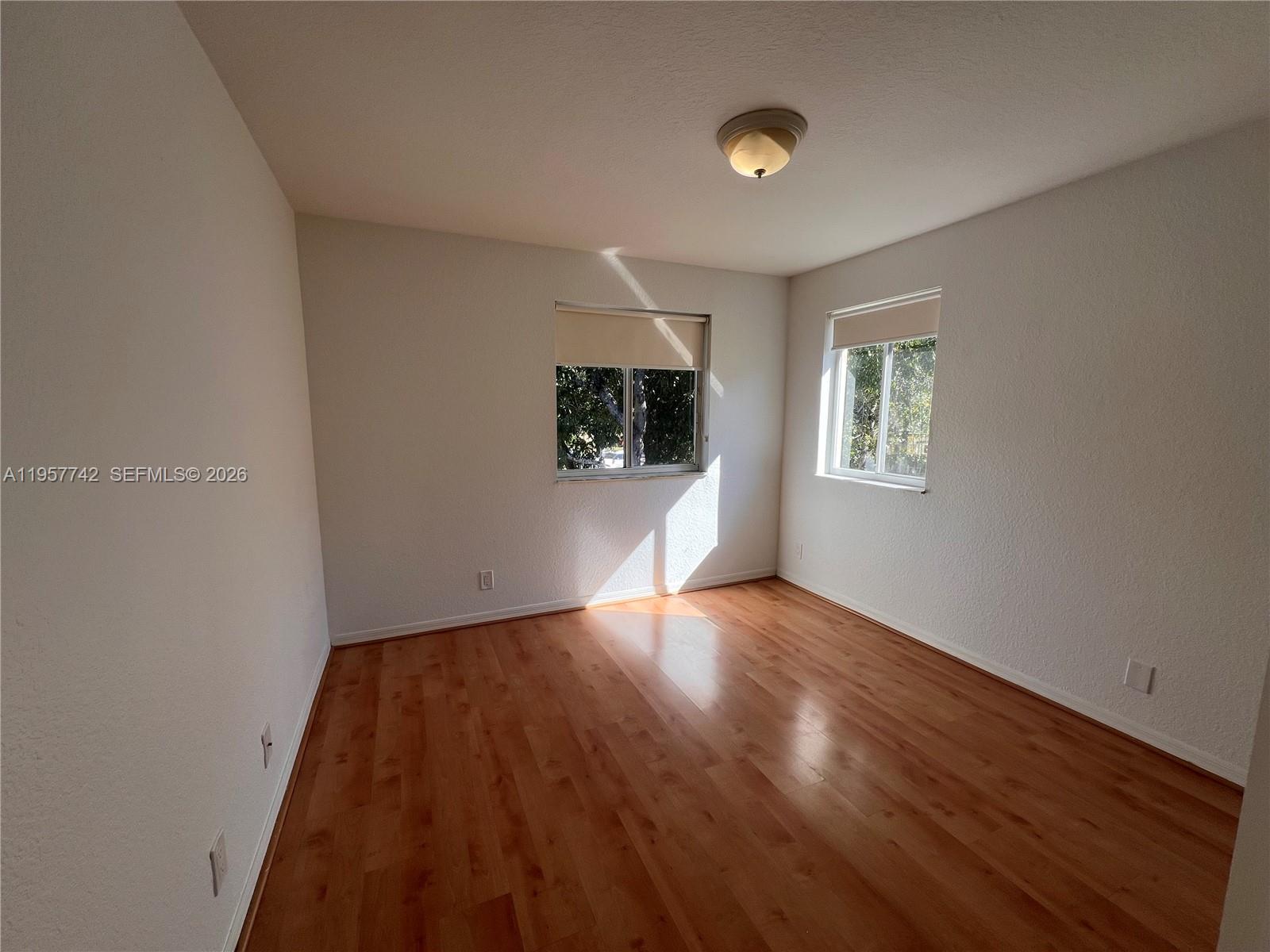 2433 Pasadena Way Weston, FL 33327 - Photo 10 of 20 a view of an empty room with wooden floor and a window