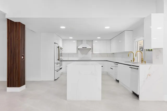 a kitchen with stainless steel appliances granite countertop a sink and white cabinets