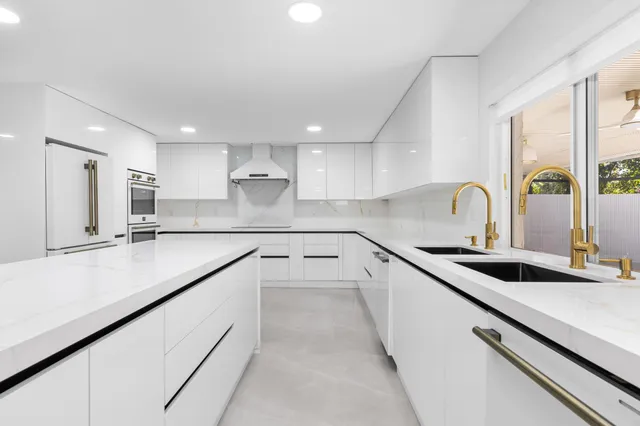 a kitchen with stainless steel appliances white cabinets and a refrigerator