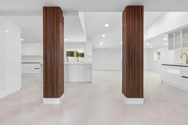 a large white kitchen with a refrigerator a sink and a stove