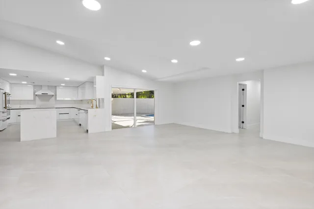 an empty room with windows and ceiling fan