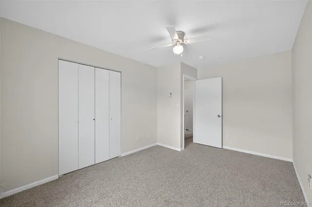 a view of an empty room and chandelier fan