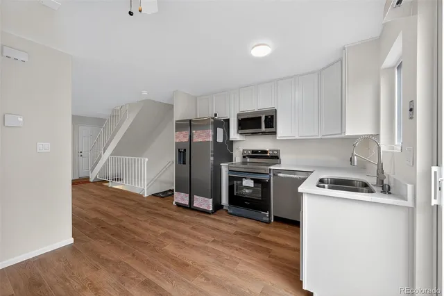 a kitchen with granite countertop a refrigerator stove and microwave