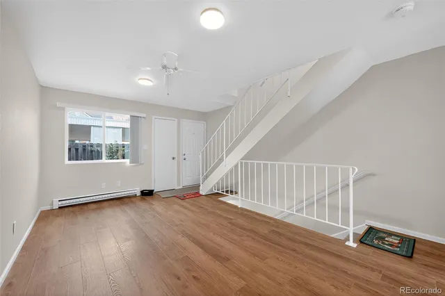 a view of an empty room with wooden floor and windows