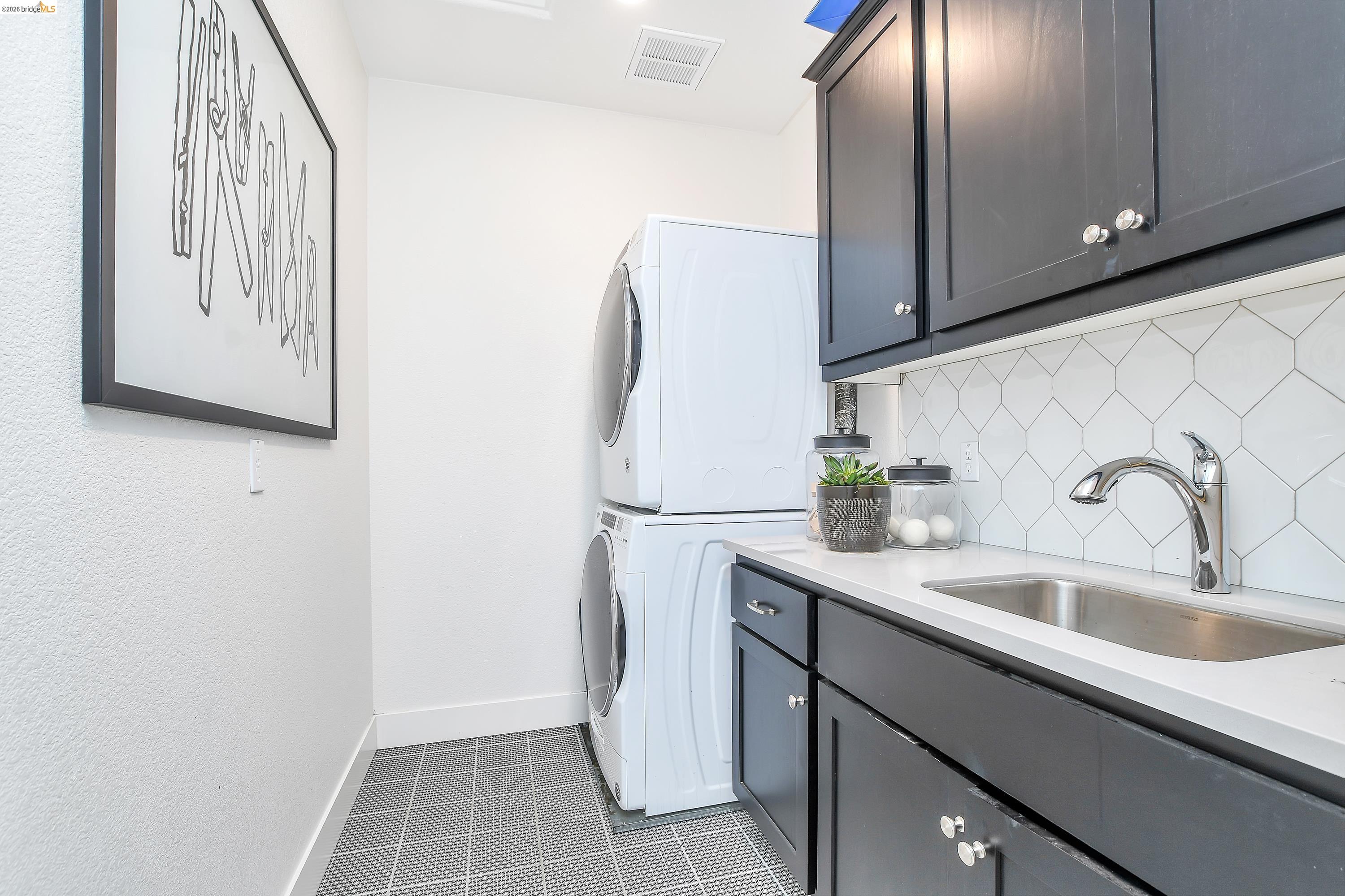 829 Hardcastle Ranch Road Oakley, CA 94561 - Photo 21 of 41 Compact laundry area with dark cabinetry, integrated stainless steel sink, and white geometric tile backsplash