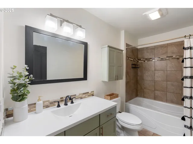 a bathroom with a sink vanity granite toilet tub and shower