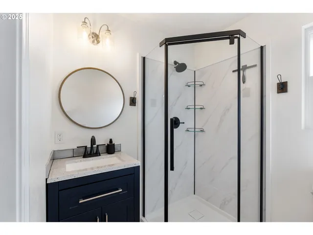 a bathroom with a sink mirror vanity and a shower
