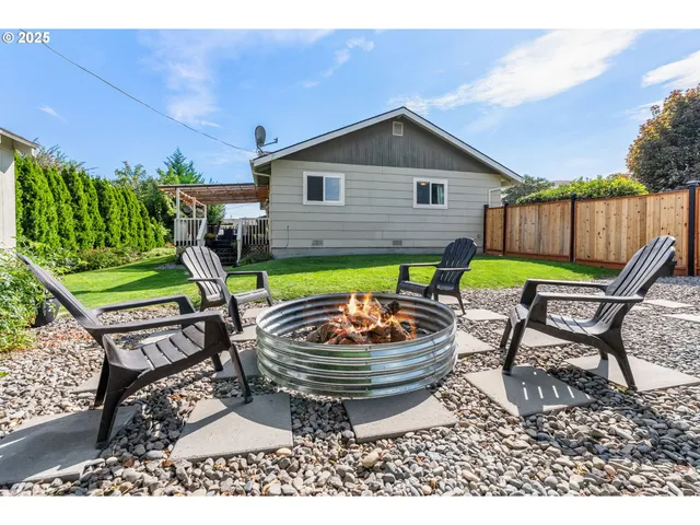 a backyard of a house with table and chairs