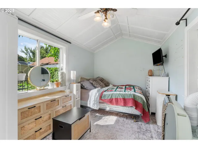a bedroom with a bed and a flat tv screen on the dresser