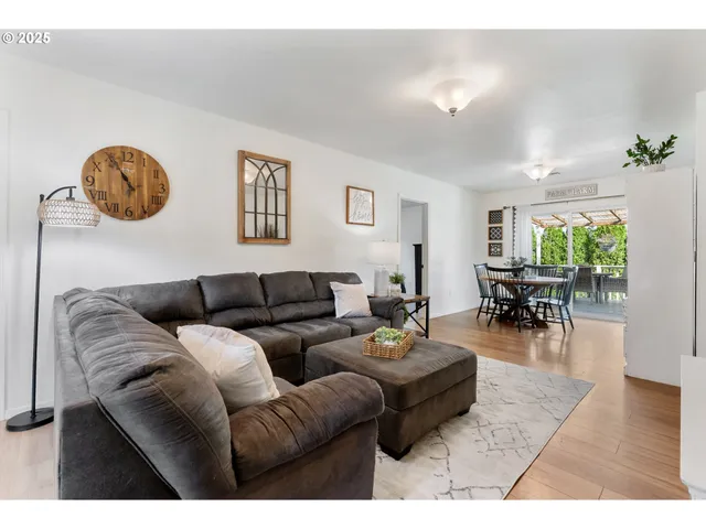 a living room with furniture a rug potted plant and a window