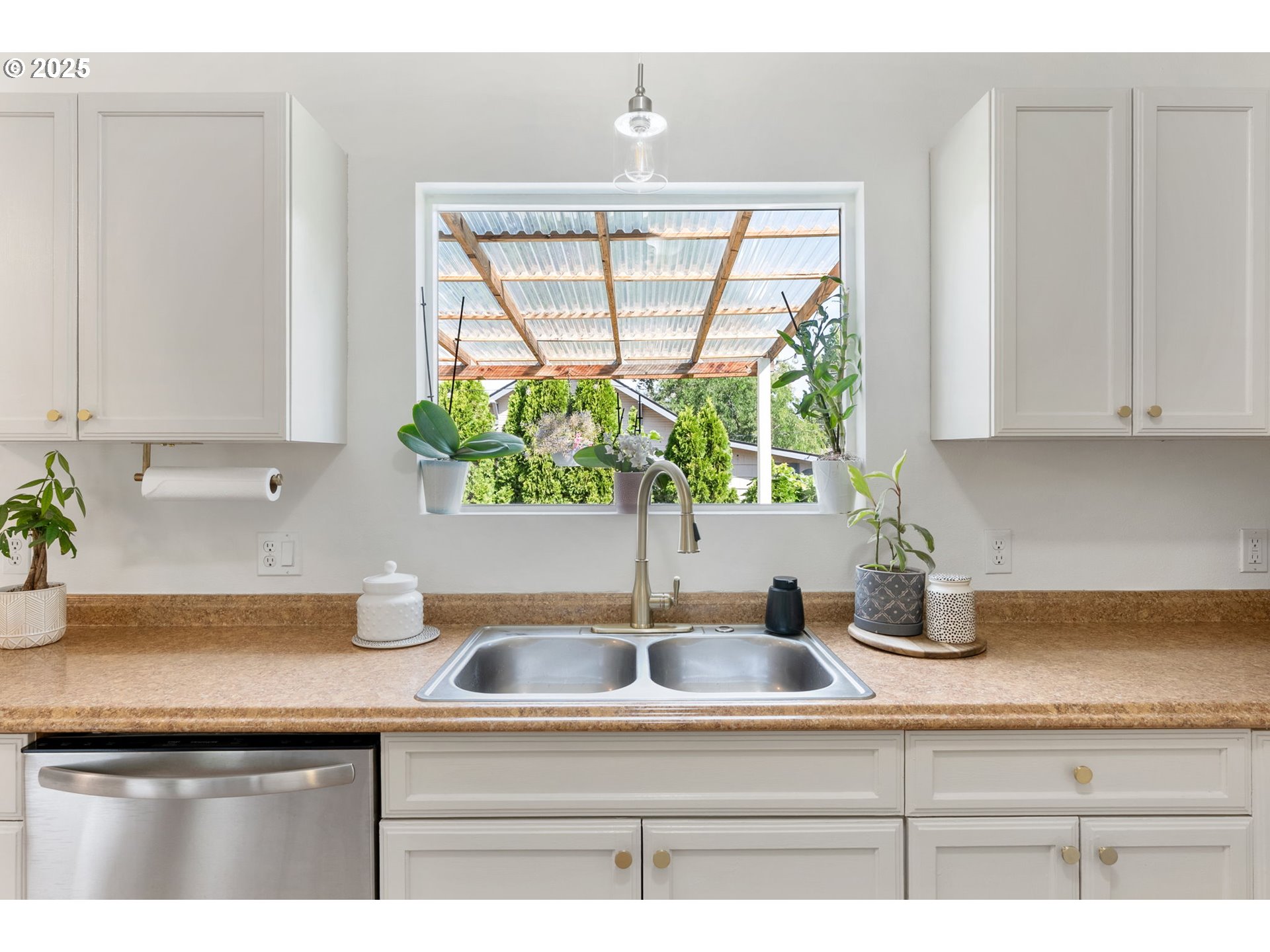 2013 East 13th Street The Dalles, OR 97058 - Photo 8 of 47 a kitchen with stainless steel appliances white cabinets a potted plant and a window