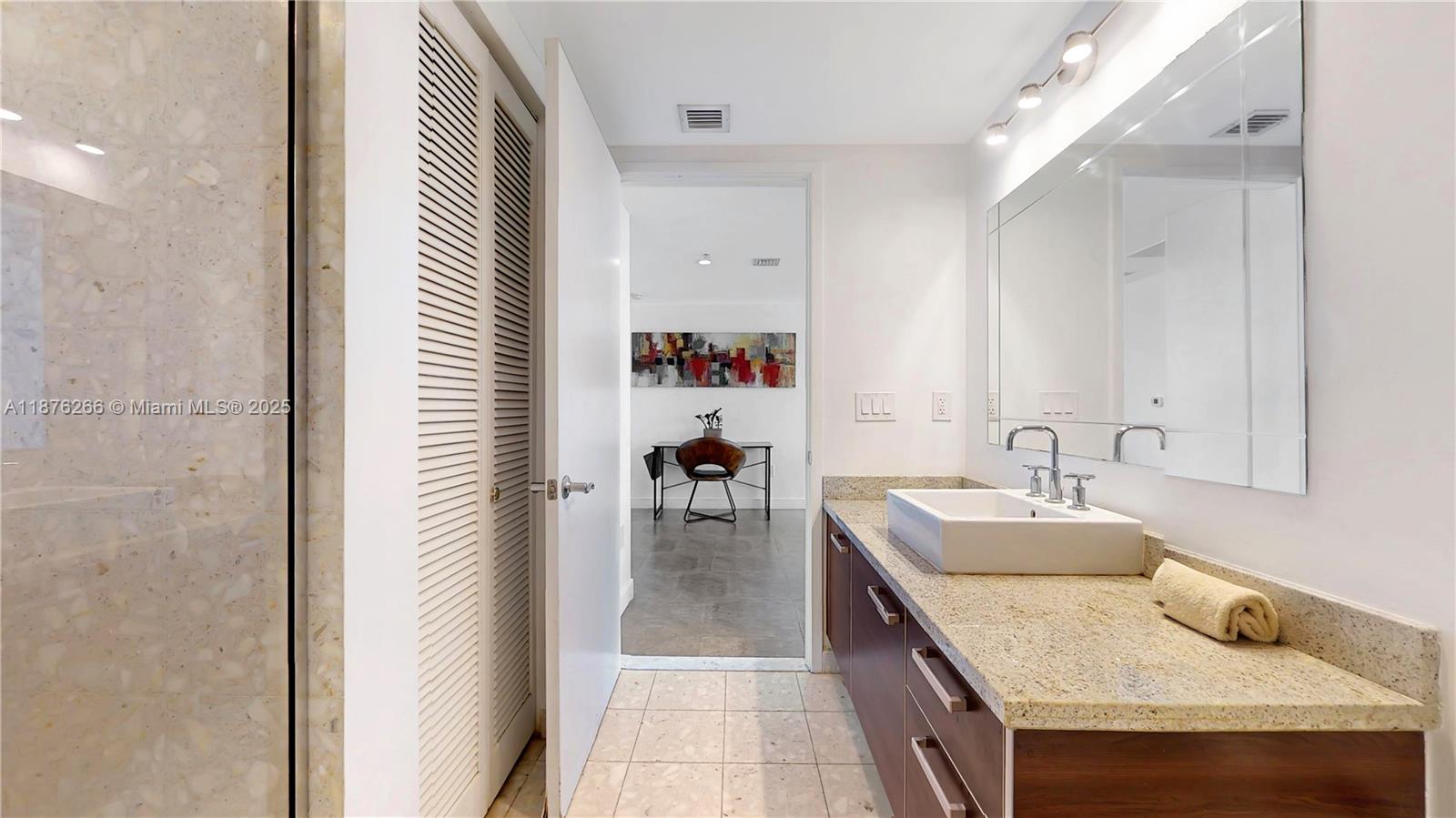 185 Southwest 7th Street, Unit 2900 Miami, FL 33130 - Photo 12 of 25 a bathroom with a granite countertop double vanity sink and a mirror