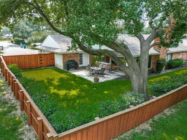 a view of backyard with deck and a garden