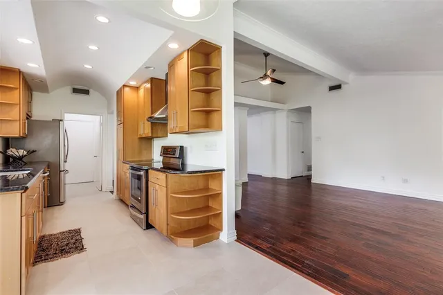 a kitchen with stainless steel appliances granite countertop a refrigerator and a stove top oven