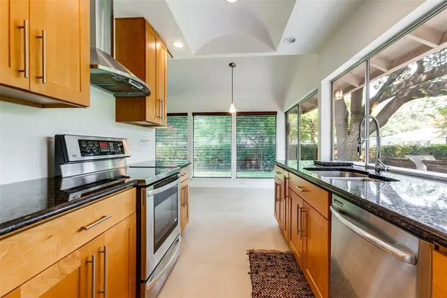 a kitchen with stainless steel appliances granite countertop a stove a sink and a microwave