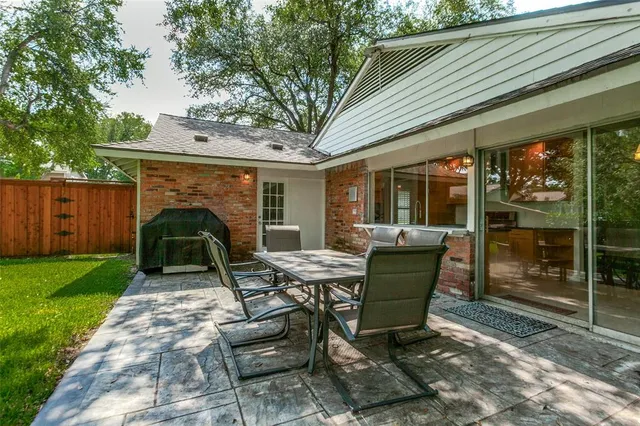 a view of a chair and table in backyard of the house