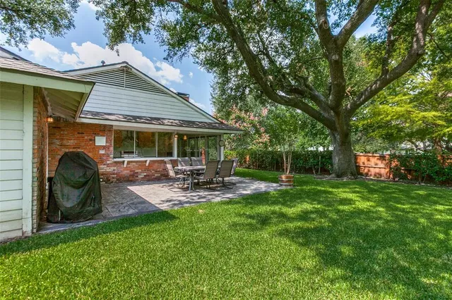 a view of a house with backyard and sitting area