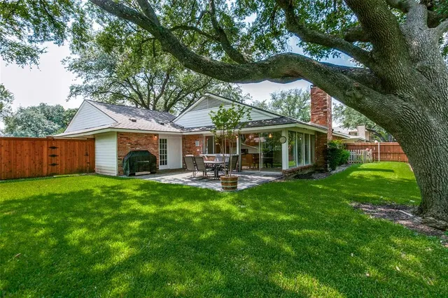 a view of house with backyard and outdoor seating