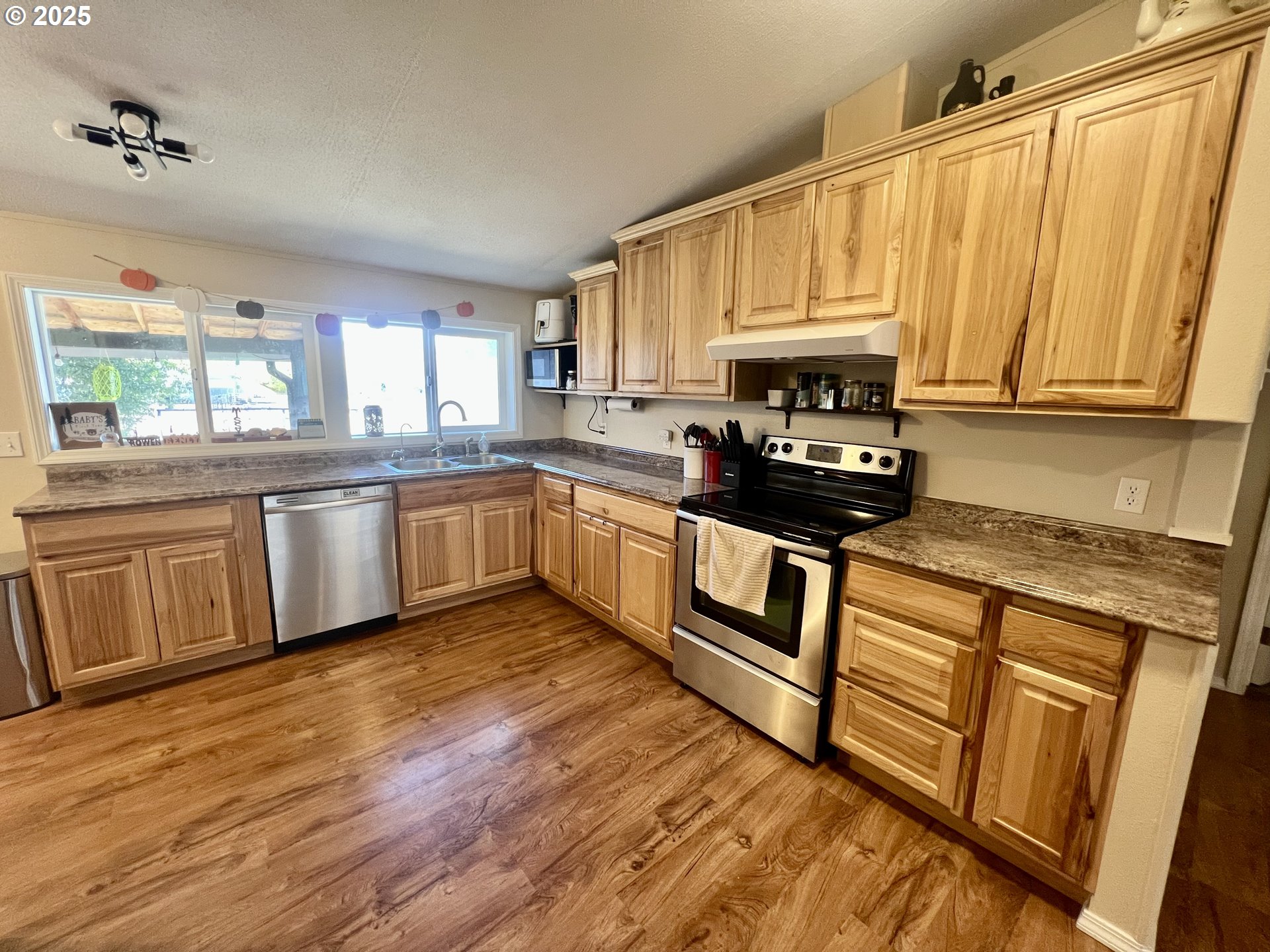 548 Pioneer Court Union, OR 97883 - Photo 6 of 18 a kitchen with stainless steel appliances granite countertop a stove a sink dishwasher and a microwave oven with cabinets